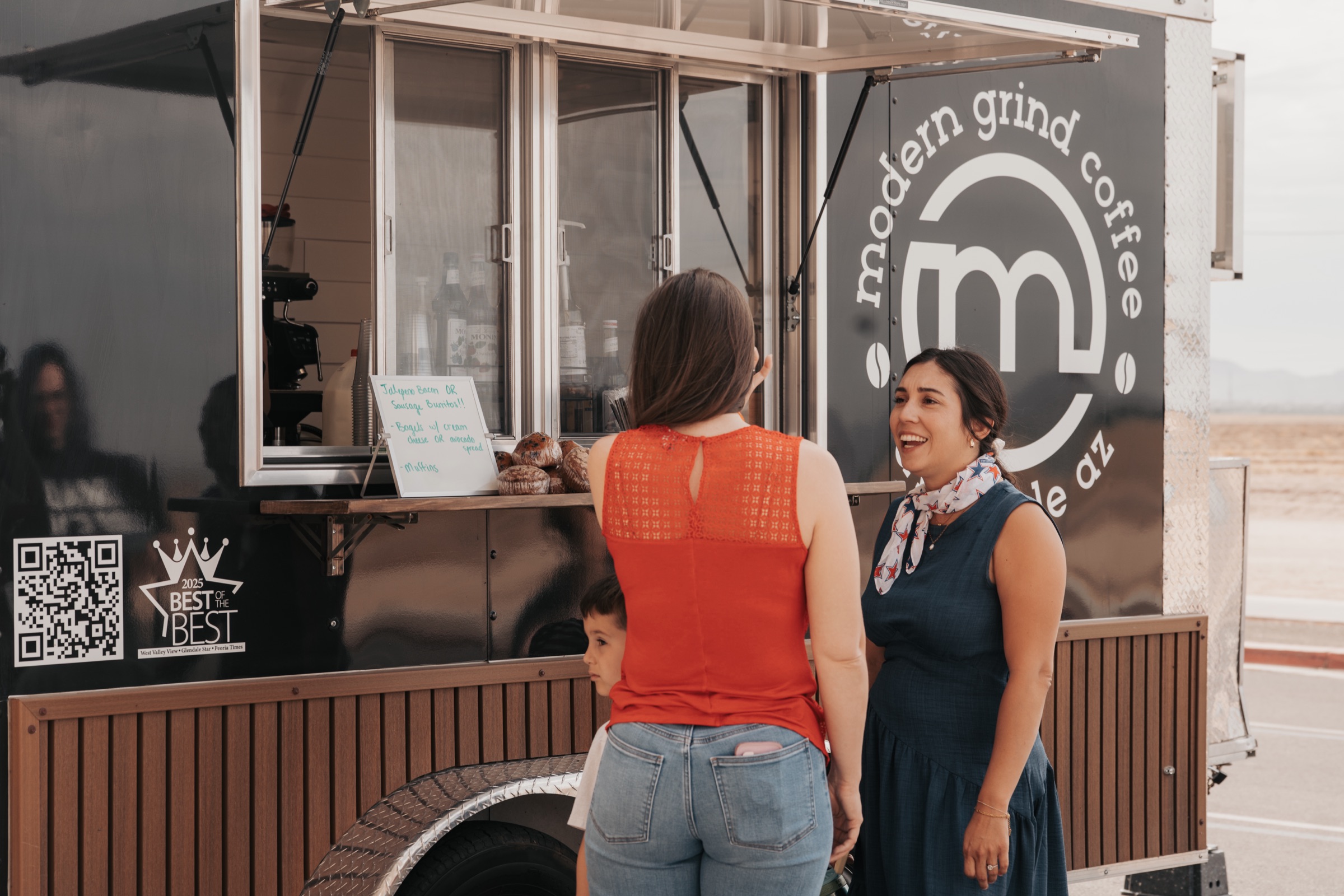 People sharing conversation around a coffee trailer