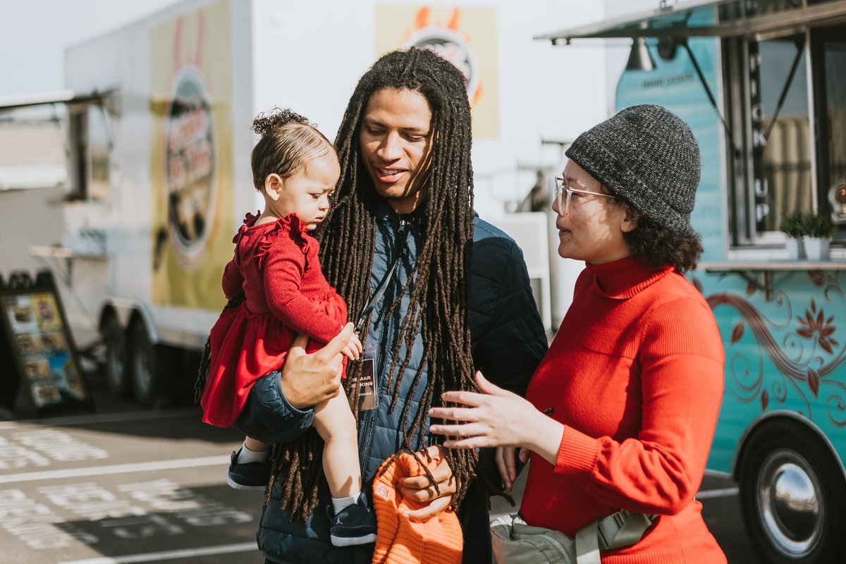 A family talking together at the food trucks during an Orbit event